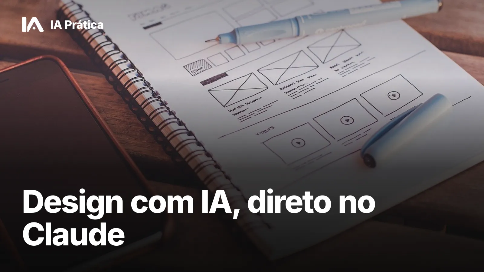 Caderno com rascunhos de telas de site desenhados à mão, ao lado de canetas e de um celular